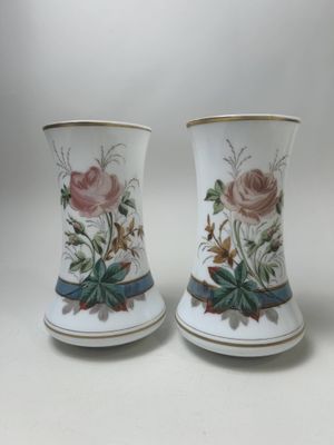deux vases avec des fleurs peintes dessus, posés sur une table