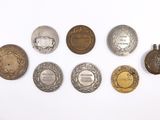 several different types of silver and gold medals on a white surface