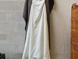 a white dress hanging on a clothes rack in a room
