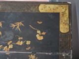 a black and gold box with flowers and leaves on it