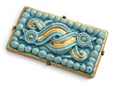 une photo d'une broche bleue et dorée sur fond blanc