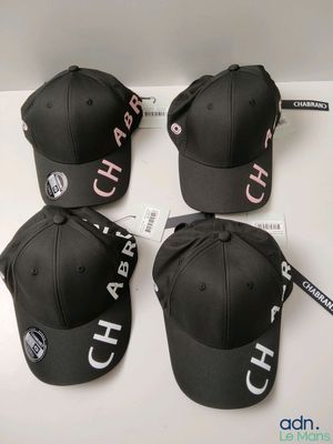 four black caps with white letters on them sitting on top of a table