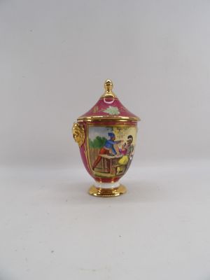 a small vase with a lid on a white surface