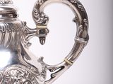 a silver teapot with a handle on a white background