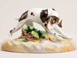une figurine représentant un chien posé sur un rocher