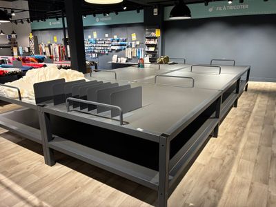 des tables et des bancs dans un magasin où de nombreux articles sont disposés au sol