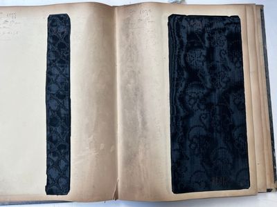 an open book with a black cover on a white table