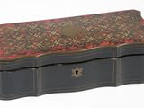 une boîte noire ornée d'un motif rouge et or