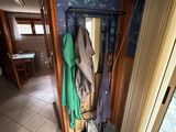 un porte-manteau dans un coin de la pièce, sur lequel sont suspendus des vêtements
