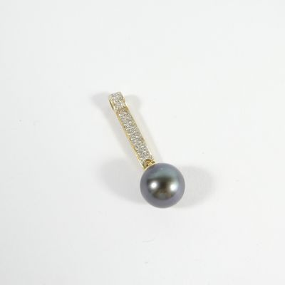 un gros plan d'un pendentif composé d'une perle noire et de diamants, posé sur une surface blanche