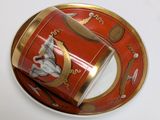 a red and gold plate with a cup and saucer on it