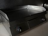 a black stove top on a white counter in a kitchen