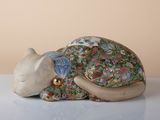 a figurine of a cat laying down on a table