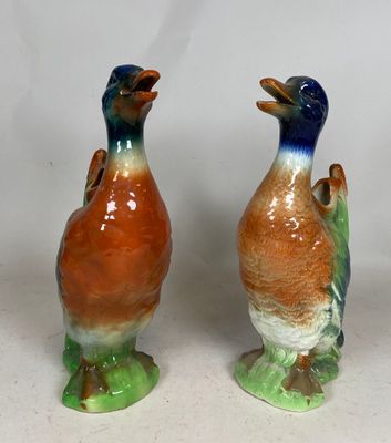 two birds that are standing next to each other on a table