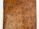 un livre marron posé sur une table blanche, avec une étiquette de prix dessus