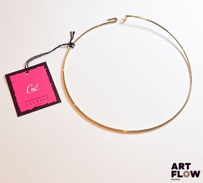 une photo d'un collier en or auquel est accrochée une étiquette rose
