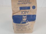 un sac de nourriture pour chat posé sur une surface blanche