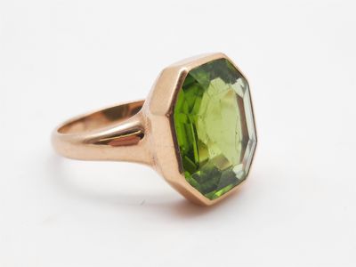 Gros plan sur une bague contenant une pierre verte