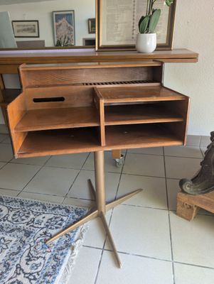 un bureau en bois sur lequel se trouvent un miroir et un vase