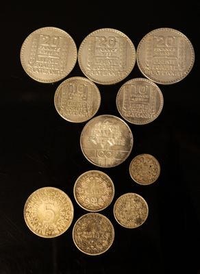 un grand nombre de pièces de monnaie qui se trouvent sur une surface noire