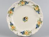 une image représentant une assiette blanche ornée de fleurs bleues et jaunes