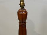 a small wooden pepper mill on a white surface