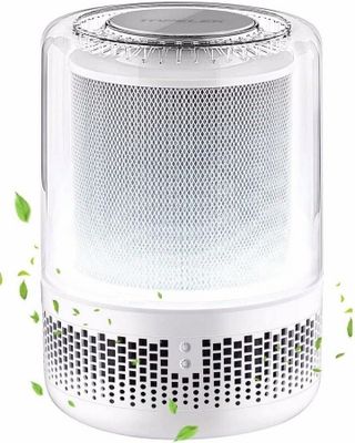 a white air purifizer with green leaves flying around it