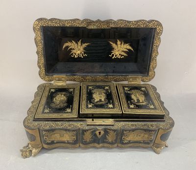 an antique black and gold jewelry box with four drawers