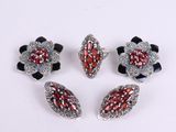 quatre bijoux en verre argenté et rouge posés sur un fond blanc
