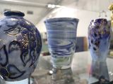 de nombreux vases posés sur une table en verre dans une pièce