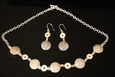 a close up of a necklace and earrings on a table
