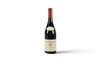 a bottle of red wine sitting on top of a white surface