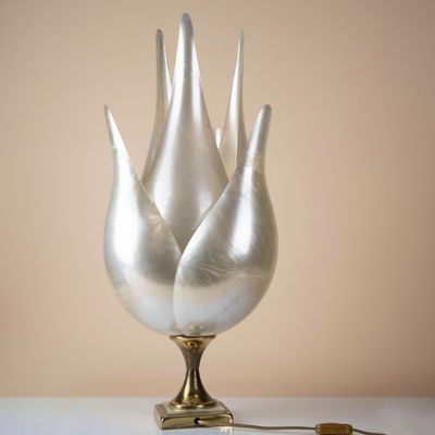three silver vases sitting on a white table