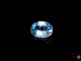 a close up of a blue topazte gems on a black surface