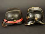 pair of fireman ' s helmets on a black background