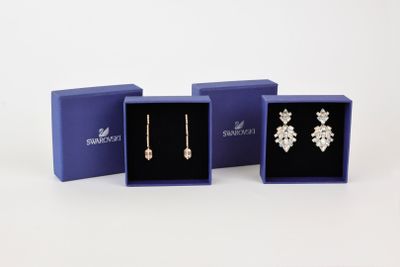 three pairs of earrings in a blue gift box on a white background