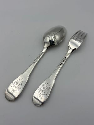 deux cuillères et une fourchette en argent sur une table