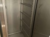 a metal cabinet with a door open in a kitchen