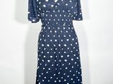 La robe est bleue et blanche, avec des pois.
