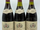 trois bouteilles de vin sont alignées sur une surface blanche