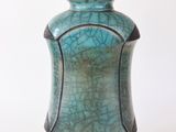 un vase bleu posé sur une surface blanche