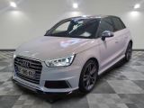 the white audi is parked on a checkered floor in a garage