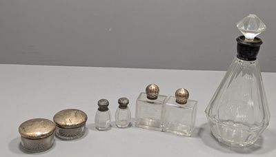 une bouteille en verre munie d'un bouchon et un ensemble de salières et poivrières posés sur une table