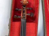 an old violin in a case on a table with a red cloth