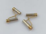 a pair of brass plated rollers on a white surface