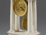 une horloge blanche et or posée sur une table