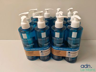 quatre flacons de gel hydroalcoolique posés sur une table blanche