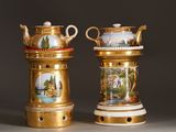 two golden vases with pictures on them on a table