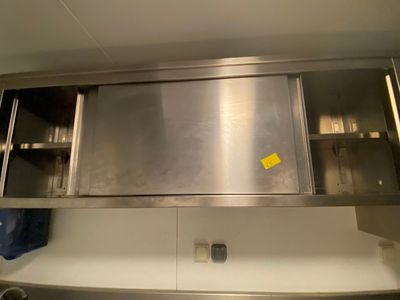 une armoire en acier inoxydable sur laquelle est apposée une étiquette jaune