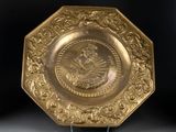 an image of a gold plate with a picture of a woman on it